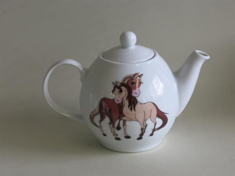 Weiße Teekanne aus Porzellan mit zwei verspielten Pferden